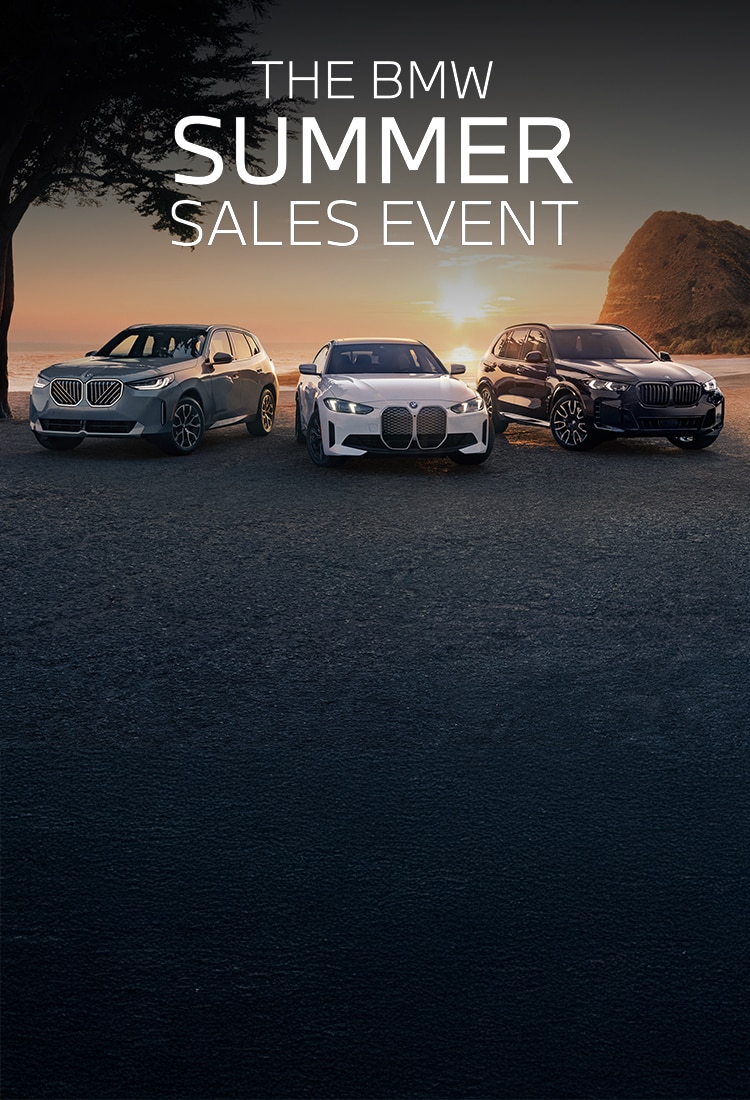 The BMW X3 30 xDrive, i4 eDrive40, and X5 xDrive50e in front of a scenic beach during sunset.