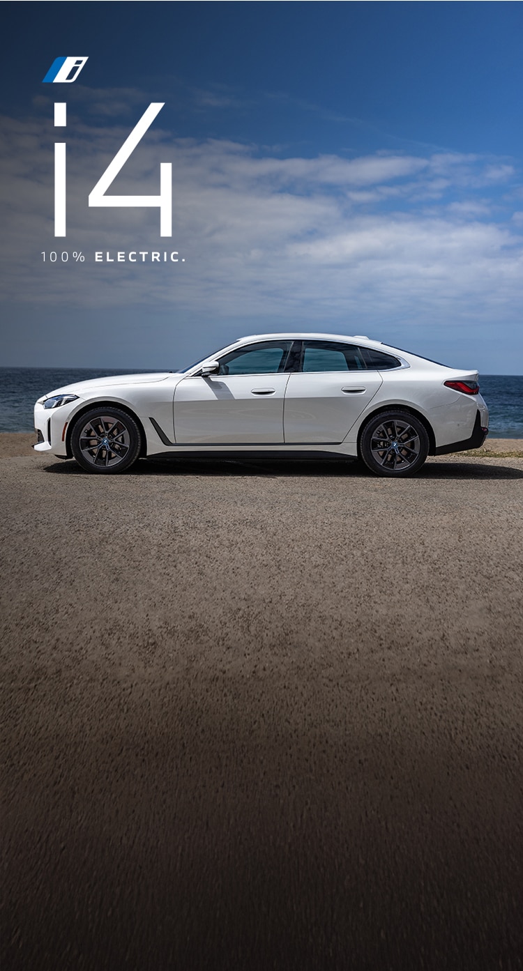 The BMW i4 eDrive40 parked on a scenic summer beach.