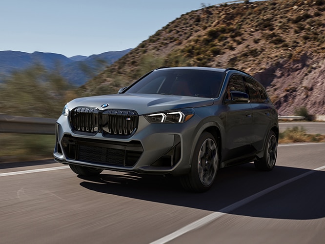 The all-electric BMW X1 M35i turns a corner on a mountain highway