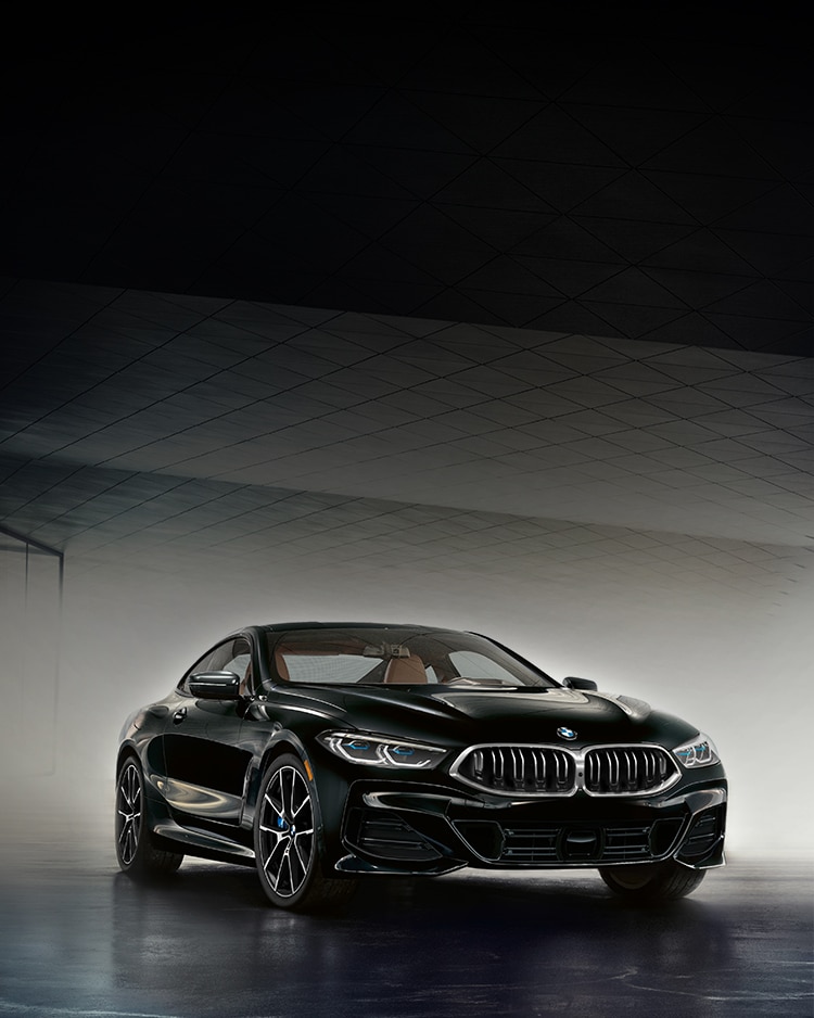 The 2025 BMW 840i Coupe dramatically lit in a modern garage