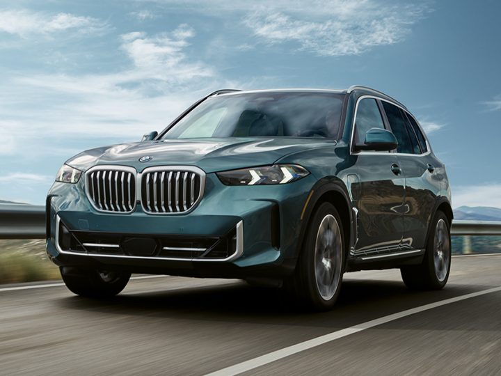 2025 BMW X5 xDrive50e  driving confidently down a road