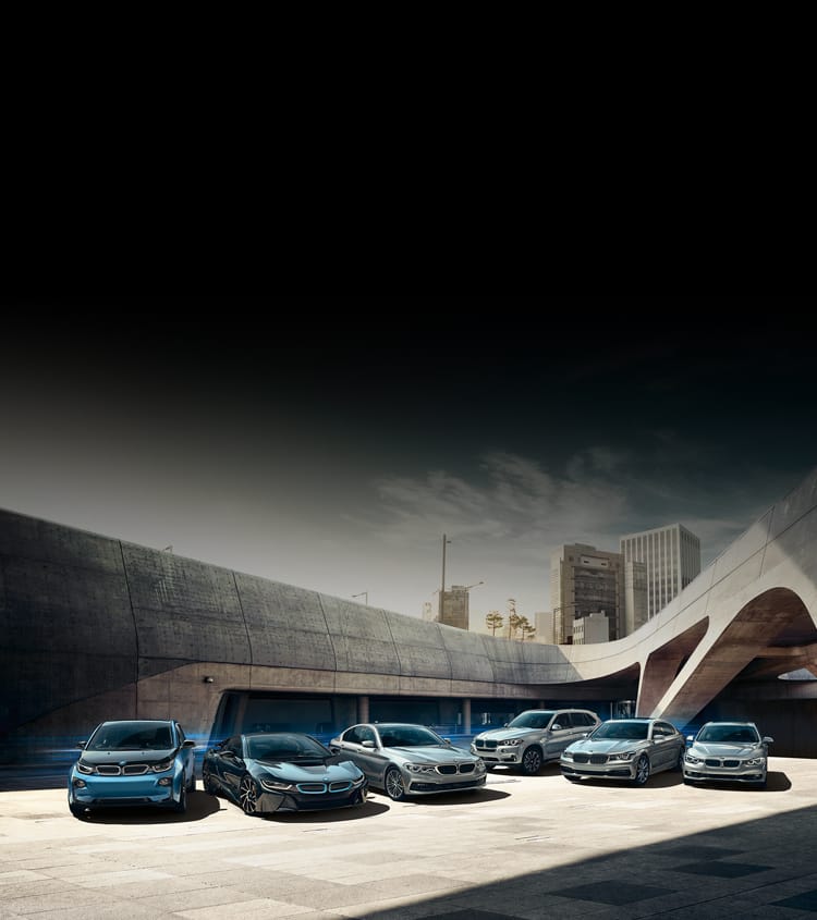 Pack shot of BMWs parked in front of futuristic bridge