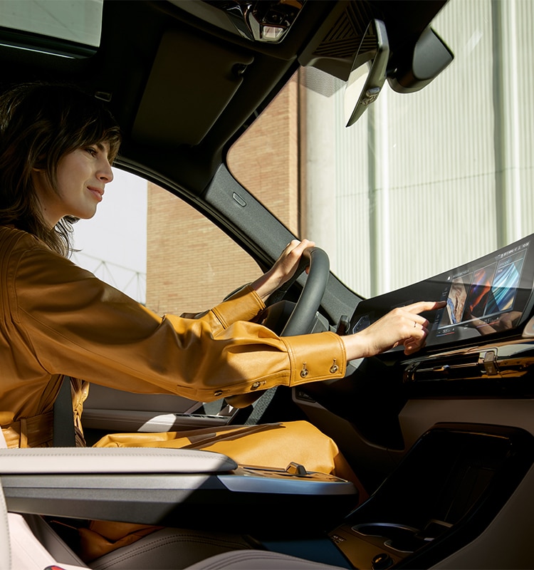 A woman interacts with the latest iDrive 8 Operating System in the 2023 BMW X1 SAV