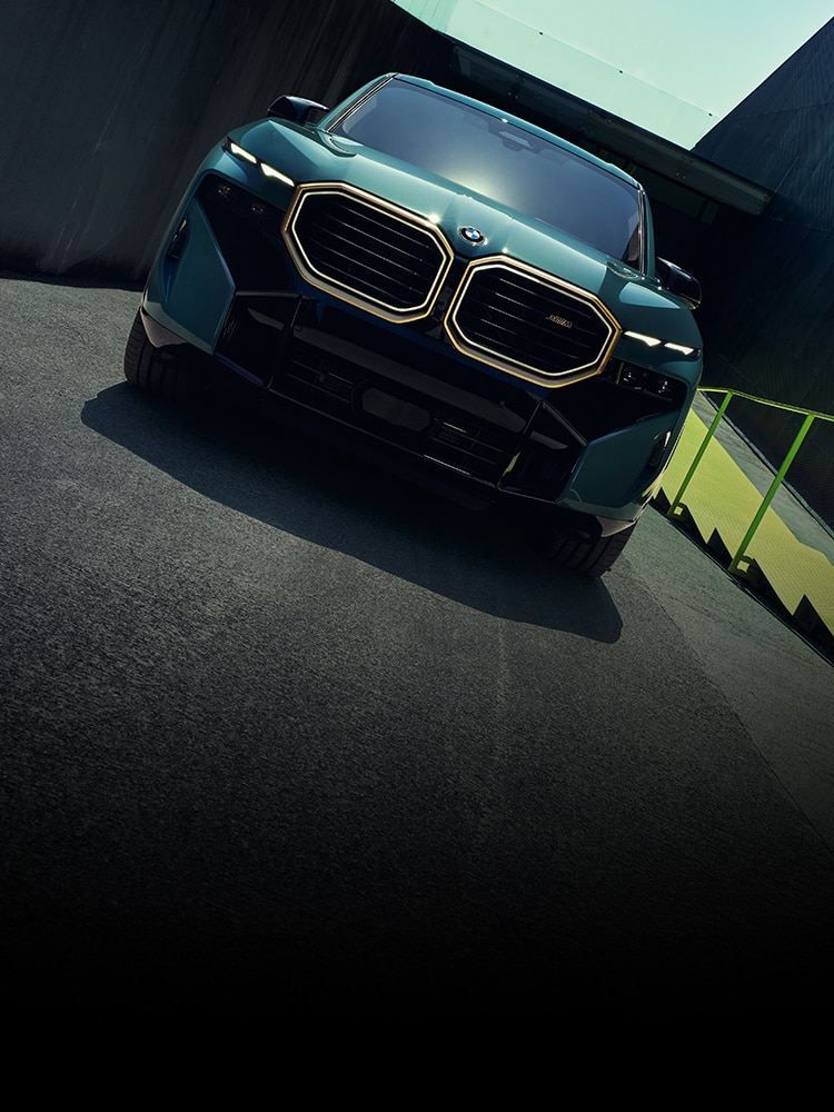 The BMW XM accelerates down an urban road