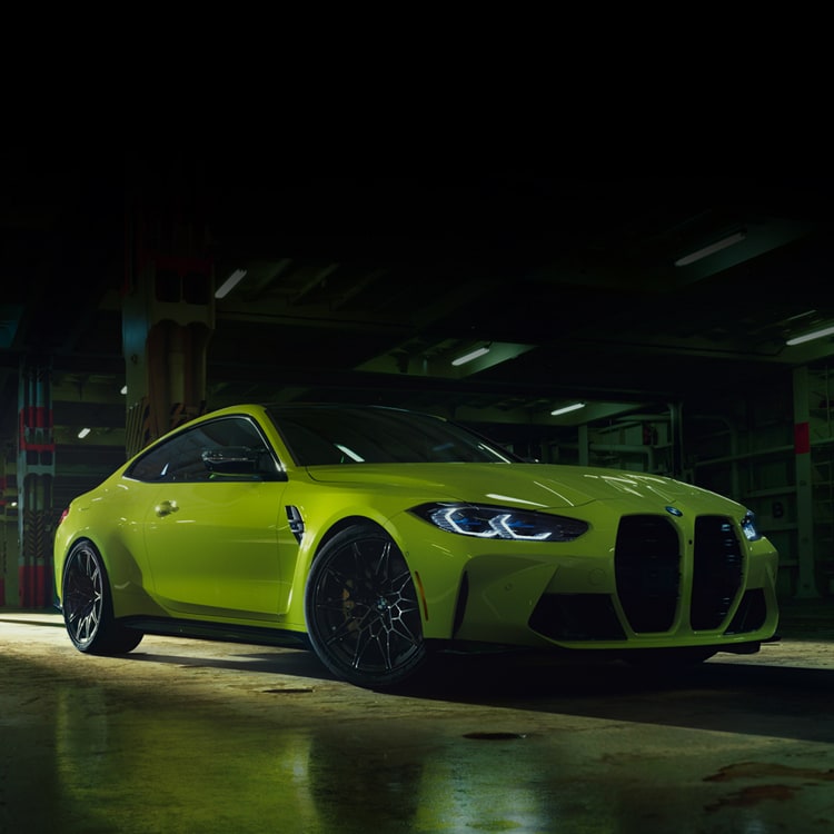 Front detail of BMW M4 in Java Green Metallic, showcasing the BMW 50 Years Emblem