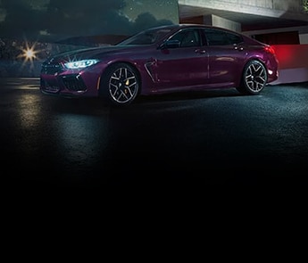 An exterior view of the M8 Gran Coupe parked outside a modern luxury home