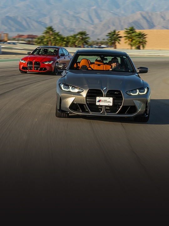 Drivers take BMW M3 Competition Sedans around a corner on the track