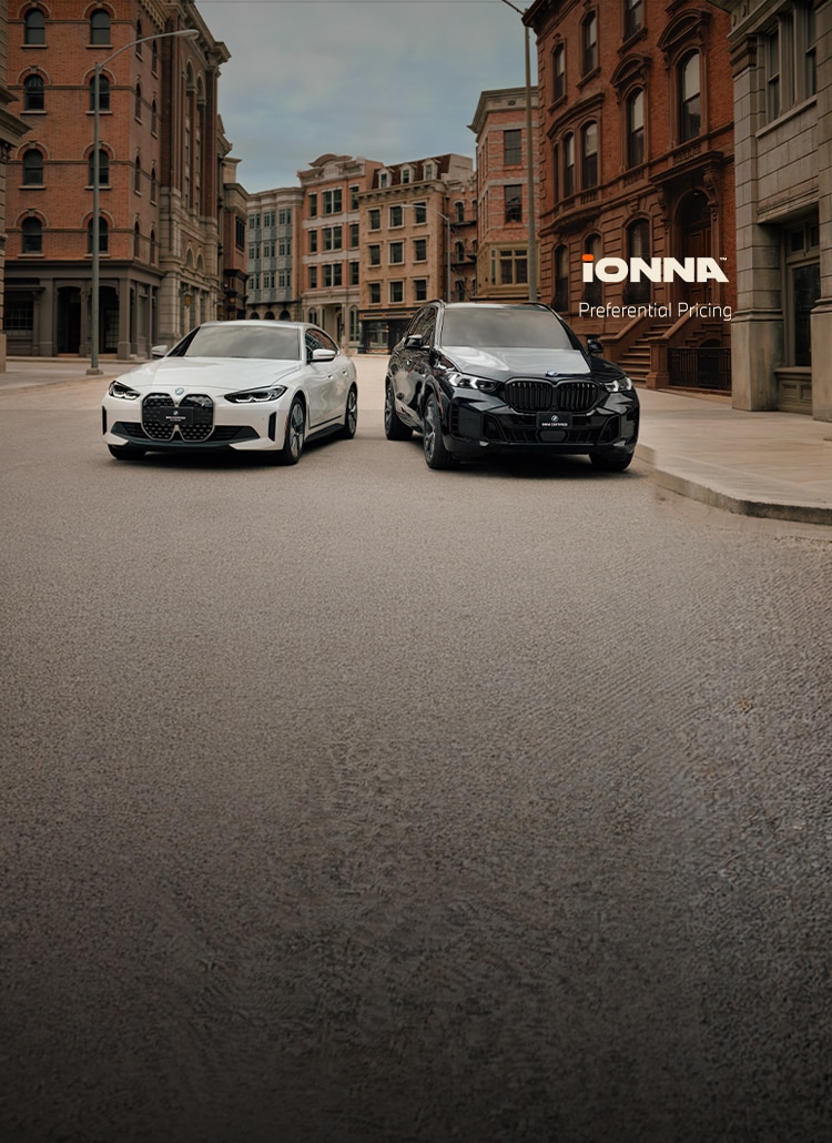 A BMW i4 and X5 xDrive50e sit parked in a city street lined with brownstone and brick buildings. The IONNA preferential pricing logo sits on the right side of the image.