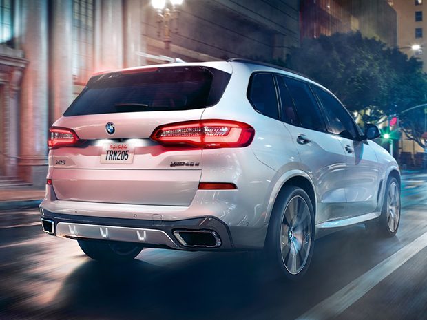 2022 BMW X5 xDrive45e SAV driving through the city at night