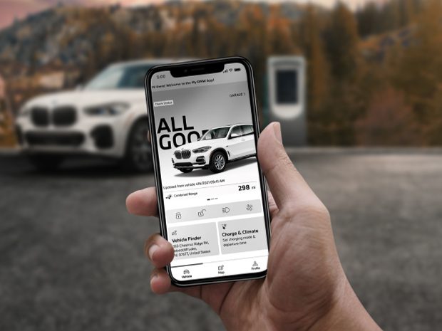 BMW driver holding up phone displaying the BMW Connected App