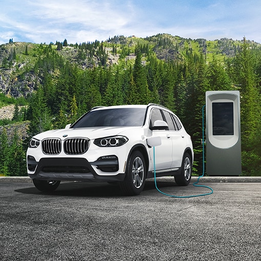A 2021 BMW X3 xDrive30e plugged into a public charging station