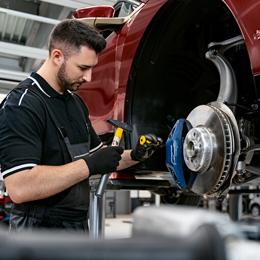 A BMW mechanic performs a repair on a BMW