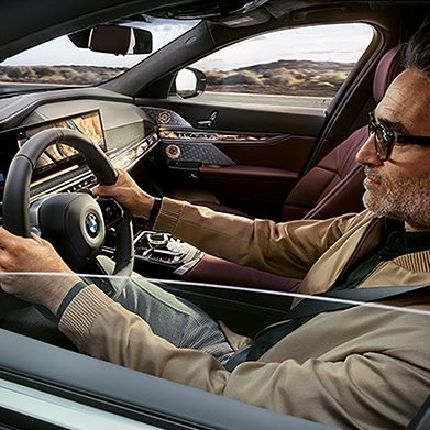 Interior shot of a confident man driving a BMW equipped with Traffic Camera Information