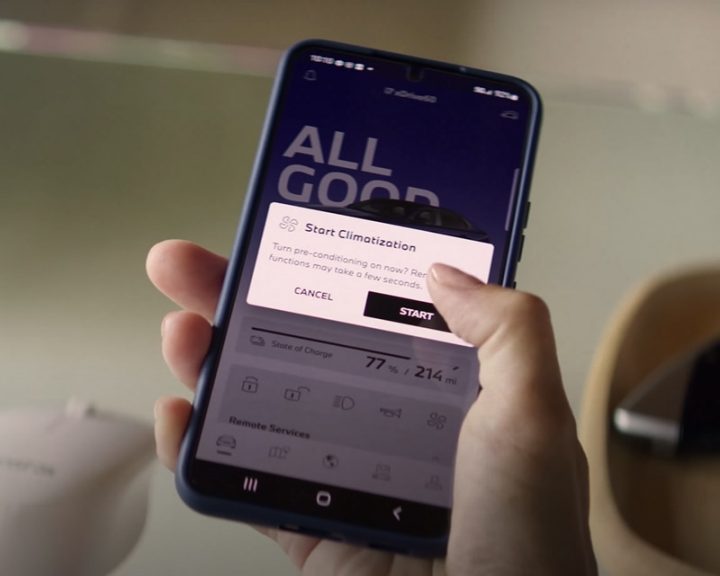 Close up on a BMW owner using their My BMW App to precondition their vehicle