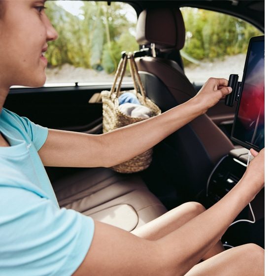 Image of young BMW passenger connecting a tablet to the onboard hotspot, showcasing BMW WiFi Hotspot compatibility