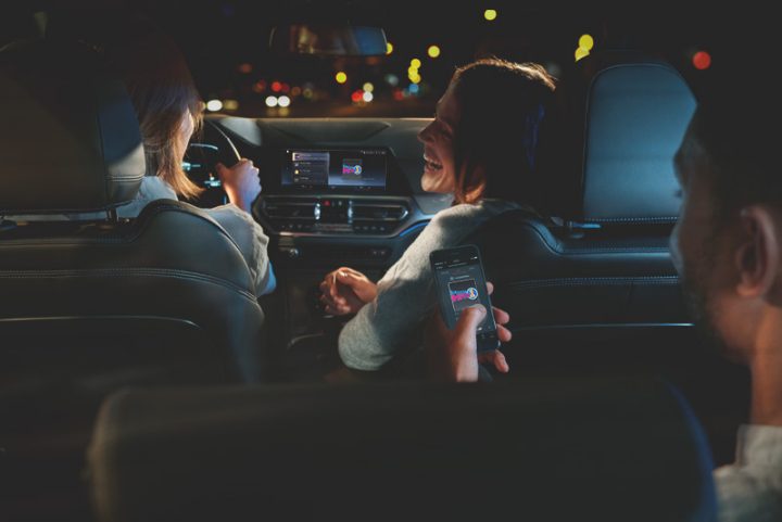 Image of a driver in a BMW and two passengers enjoying personalized entertainment options, showcasing range of BMW ConnectedDrive features and services