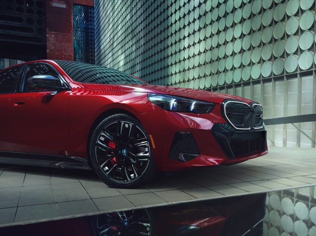 Side profile image of a BMW parked against a modern building