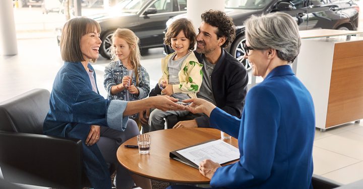 A young family works with a BMW dealer to finalize a finance purchase