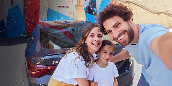 A happy family poses for a selfie with their new BMW