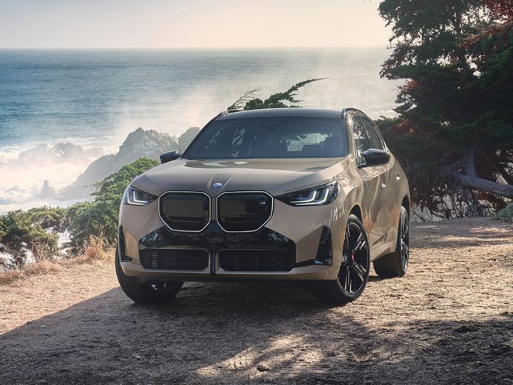 A BMW parked next to a scenic ocean