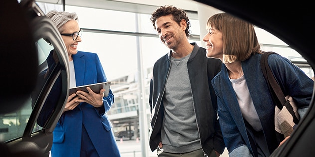 A happy young couple works with a BMW dealer to purchase a BMW