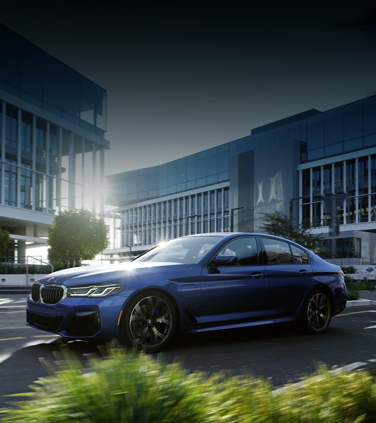 Blue BMW sedan turning the corner in office park