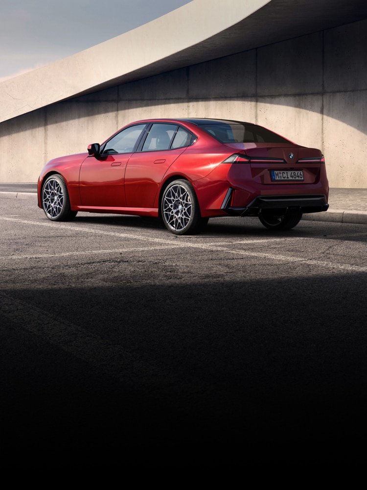 The BMW 3 Series Sedan parked in front of a cement structure.