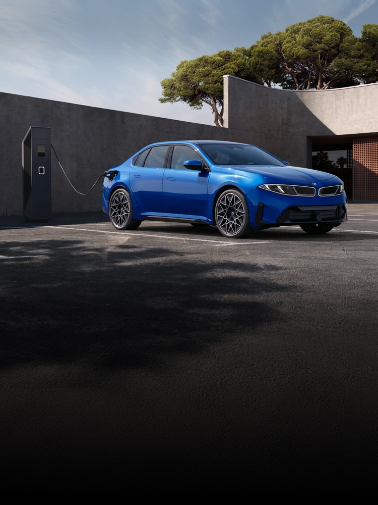 The BMW i3 parked in front of a modern cement structure.
