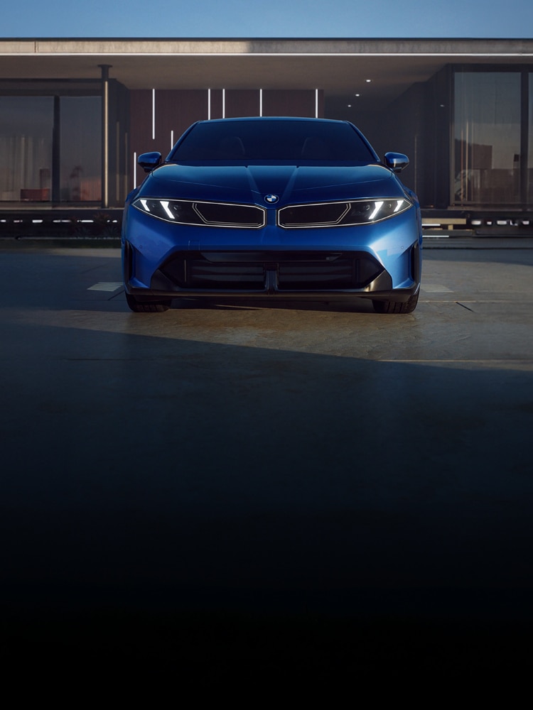 Dramatic low front view of the 2027 BMW i3 Sedan parked in front of a modern home