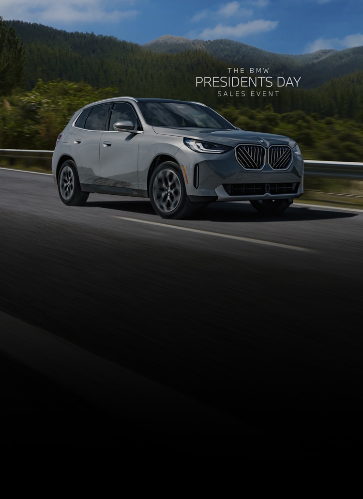 A BMW X3 drives on a winding mountain road