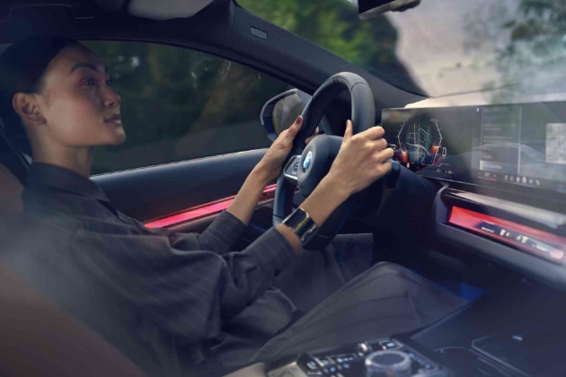 Interior shot of a driver holding the steering wheel of her  BMW i5 eDrive40