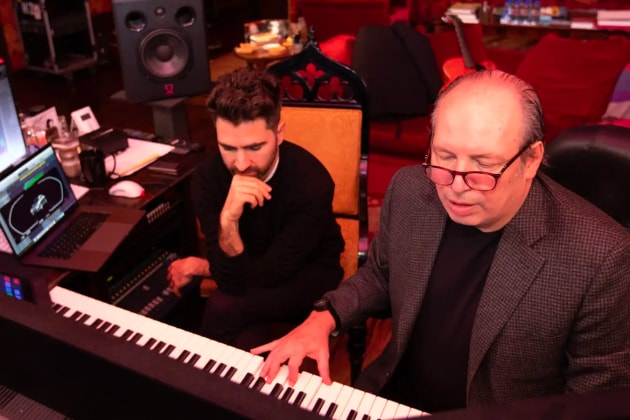 The composer Hans Zimmer plays the keyboard as his collaborator listens carefully