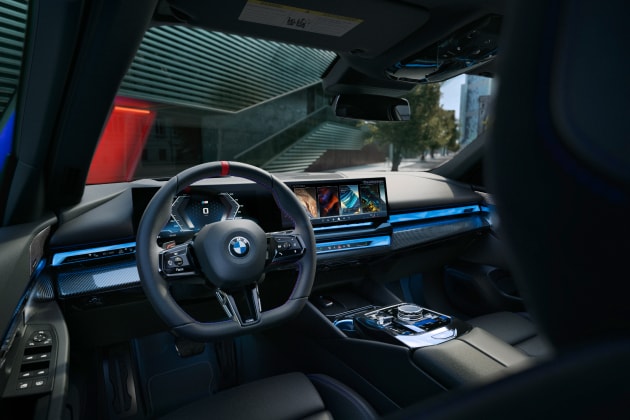 Driver's eye view of the i5 M60's interior cabin aglow with captivating blue ambient lighting