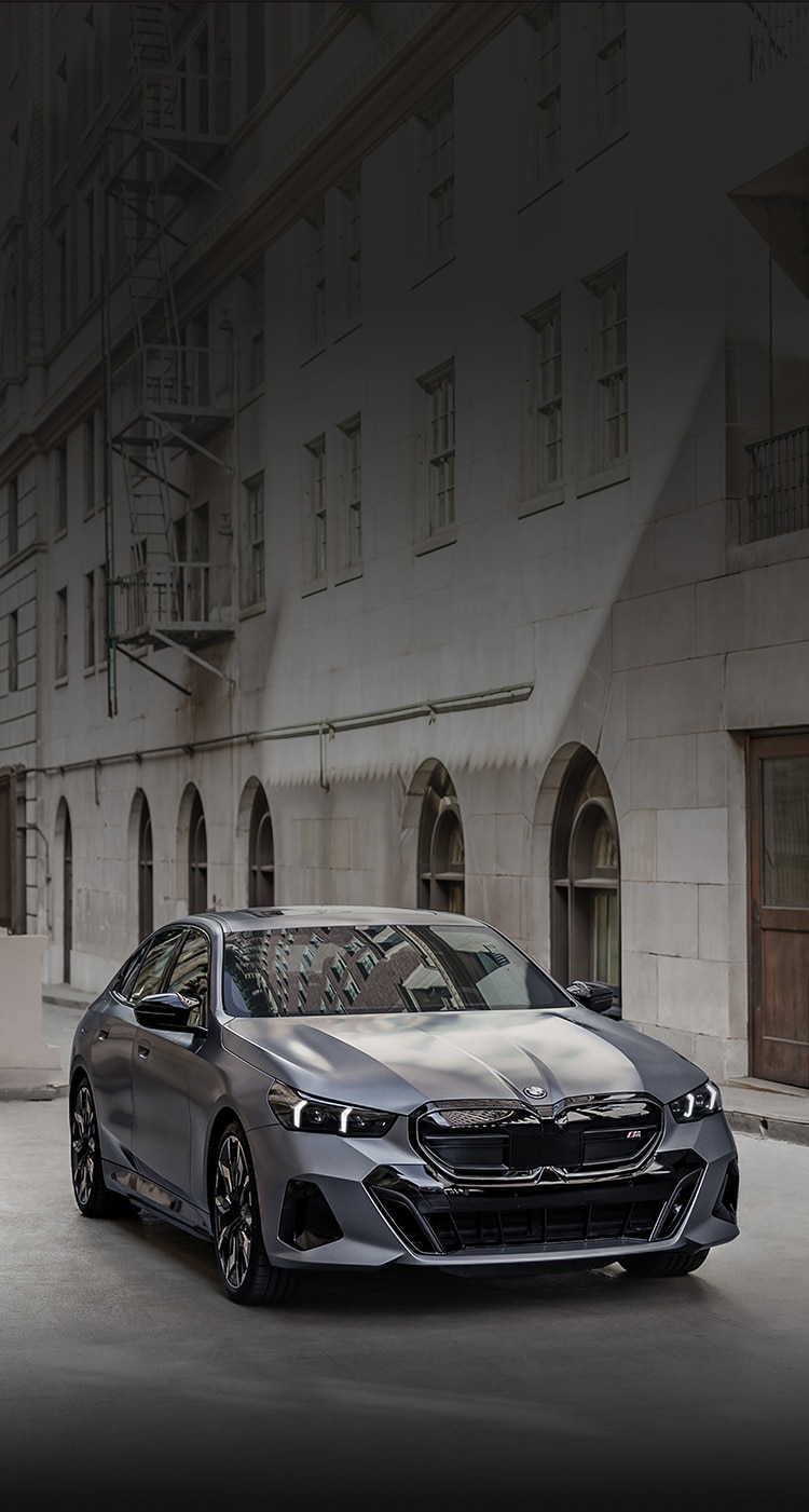 Front quarter view of the BMW i5 M60 Sedan parked in an urban alley