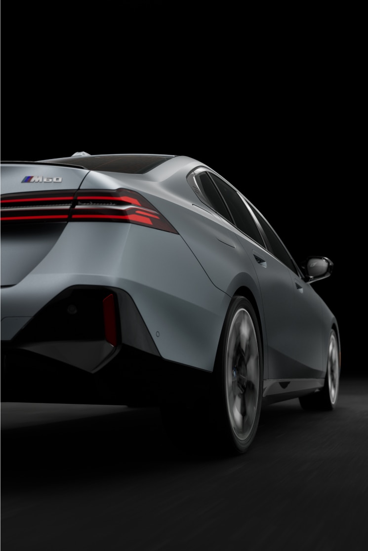 Low rear view of the BMW i5 M60 Sedan against a bold black background