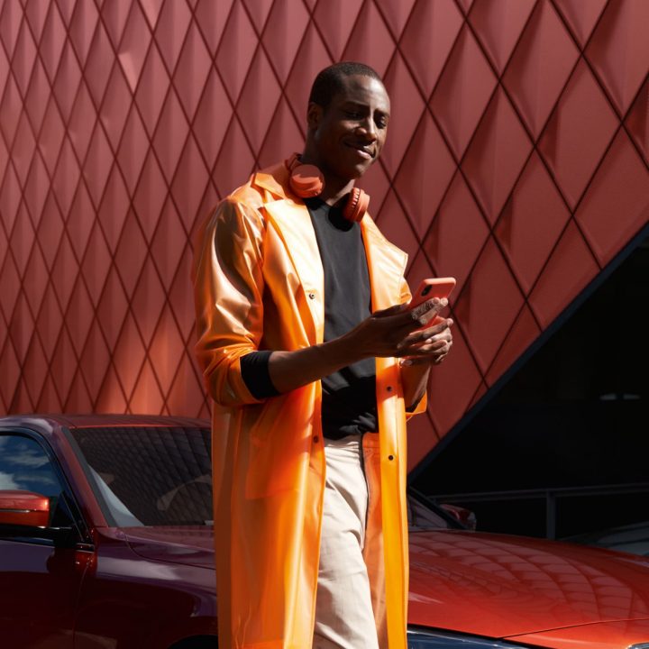 BMW Driver using My BMW App with BMW in background