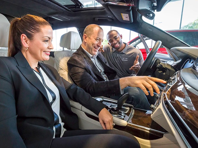 Interior shot BMW team member helping BMW drivers with the features in cockpit
