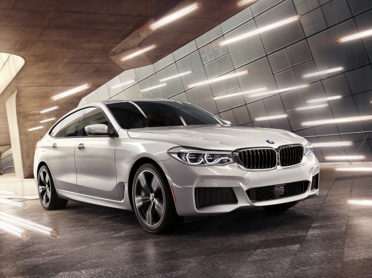 The BMW 6 Series Gran Turismo driving through a futuristic parking garage surrounded by dynamic lights