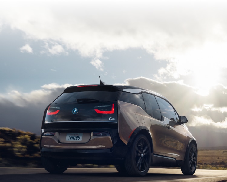 Rear shot of the BMW i3s driving through mountainous terrain