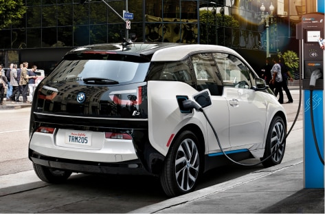 A BMW i3 Electric Sedan charging at a public charging station