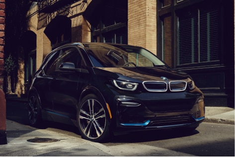 A BMW i3s drives through a city