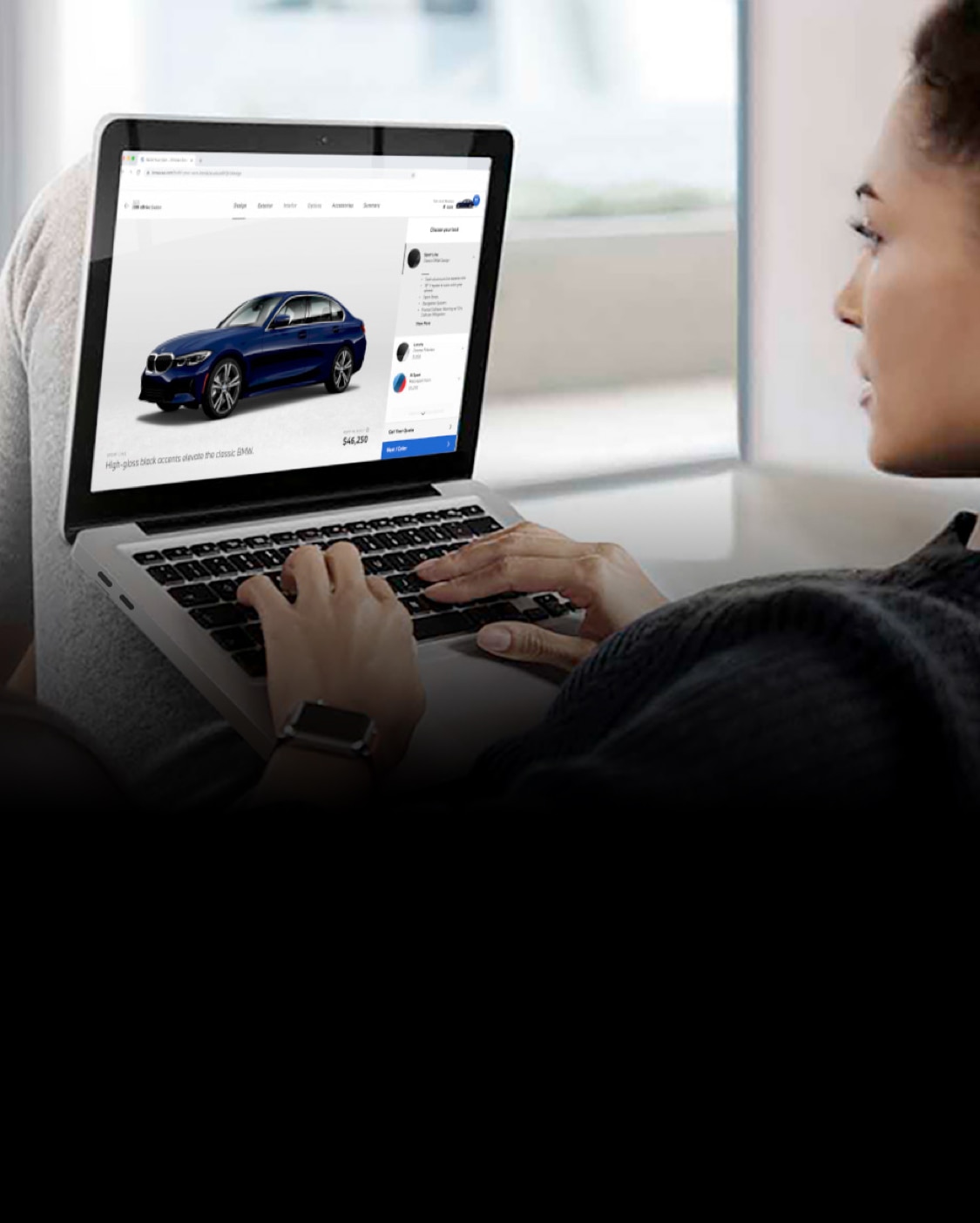 A woman uses her laptop to build a BMW 3 Series using the online configurator 