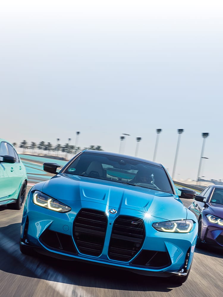 Dynamic shot of three M3 Sedans finished in BMW Individual paint on a racetrack