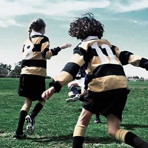 Kids play sports on an athletic field