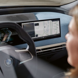 Interior shot of a driver in the BMW iX featuring the BMW Curved Display