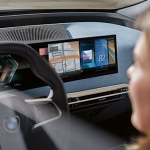 Interior shot of a driver in the BMW iX featuring the BMW Curved Display