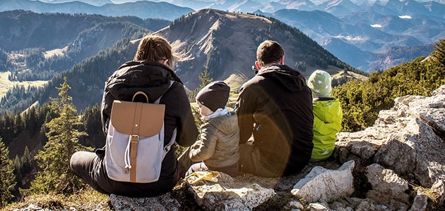 A family with two young kids take in the views from a mountaintop 