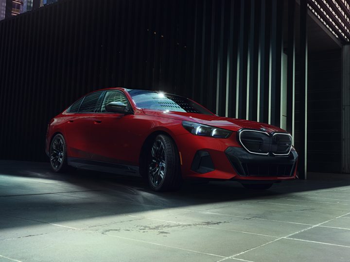 Angled front-to-side view of the BMW i5 M60 in a sleek urban environment