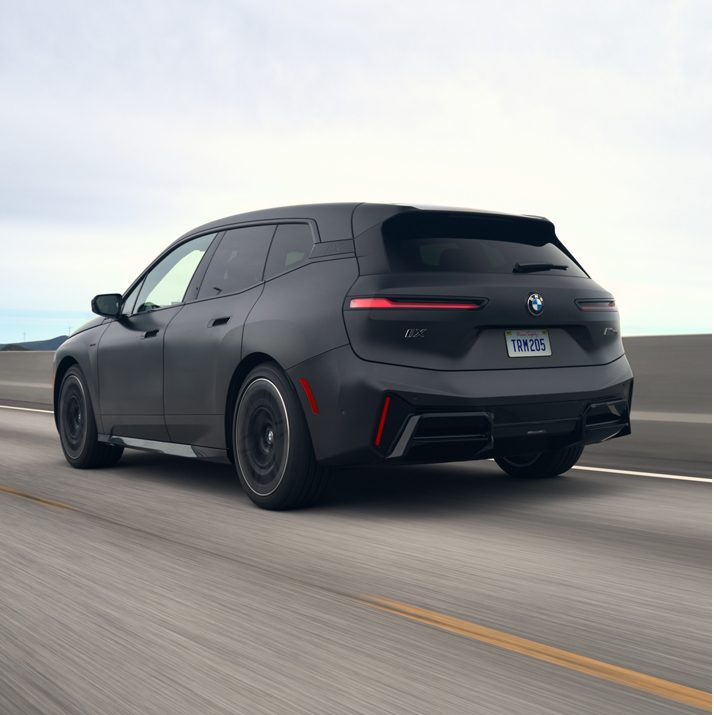 Image of the BMW iX and BMW i4 electric vehicles accelerating down the HOV lane