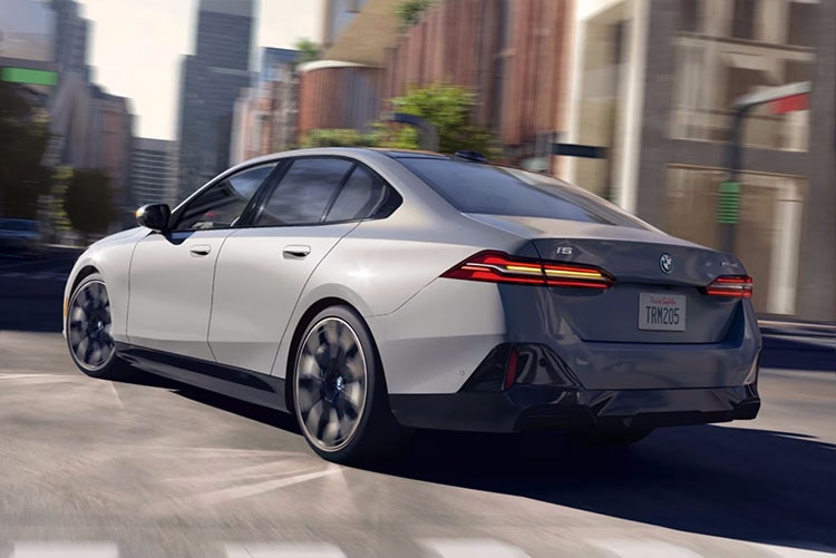 Dynamic shot of the BMW i5 eDrive40 turning left at an urban intersection
